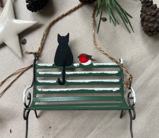 Hanging Christmas decoration by Shoeless Joe. Black Cat On Park Bench